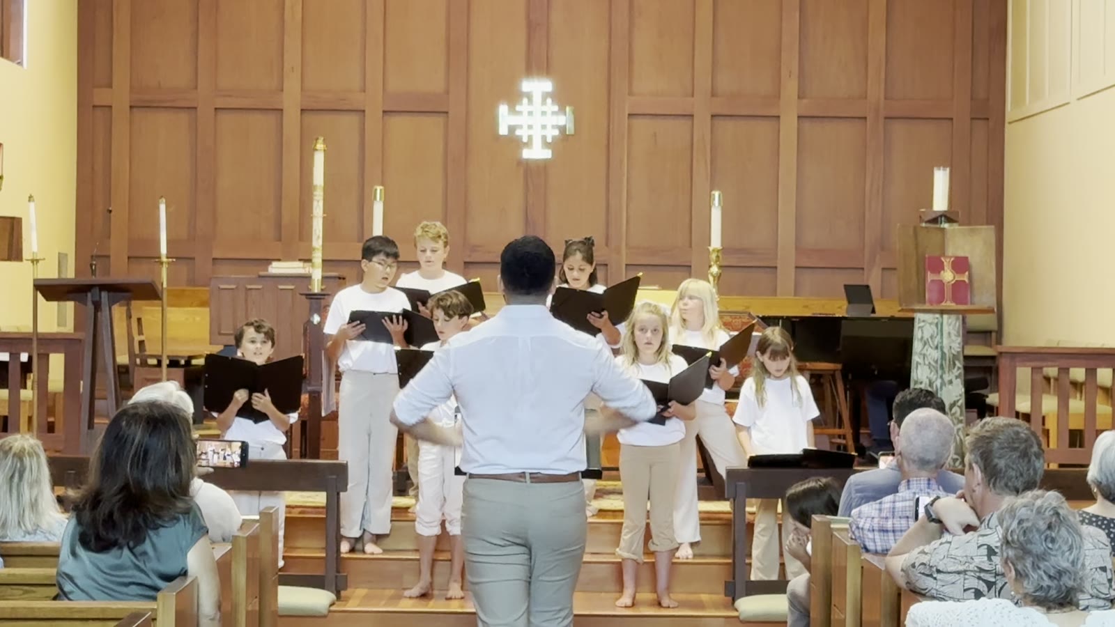 Young singers standing side by side as the audience listens